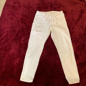 Creamy white lace up pants.